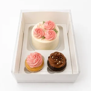 Caja blanca con tapa transparente de acetato para mini pastel y cupcakes decorados en tonos rosados y chocolate